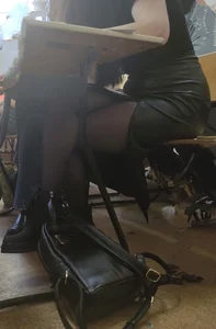 Candid college teen wearing a leather skirt sitting at her desk with crossed legs creepshots