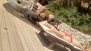 Sexy girl stretching herself while laying on sunbed