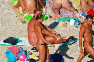 Nudist couple on the beach, girl has amazing tits and nice ass in a thong