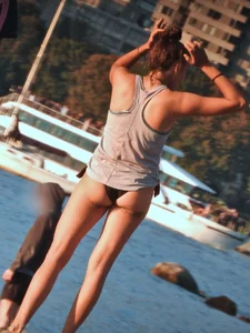 Sexy beach girl in a Nike sports bra and black bikini bottom