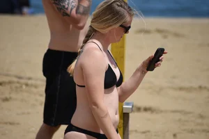 Chunky blonde in a black bikini on the beach