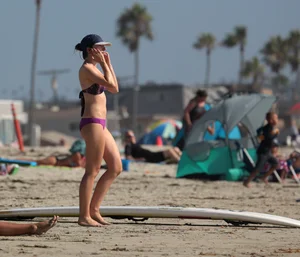Beach babe in purple bikini with nice mound, booty and slight camel toe