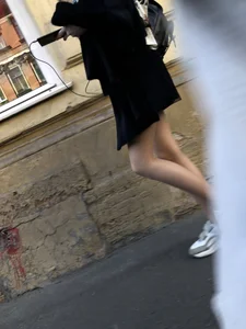 Nice slim legs of a candid girl wearing a leather skirt