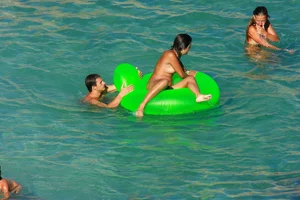 FKK Nudists playing in the water with floater
