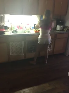 Girlfriend wearing shorts barefoot at the kitchen home creepshot