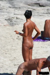 Smoking milf at a nude beach with a hairy pussy