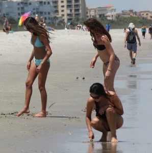 Brunette and redhead on the beach in bikinis looking sexy