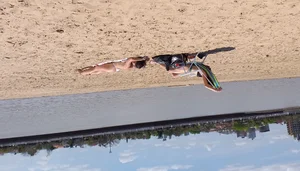 Girl laying out getting sun in a white thong bikini