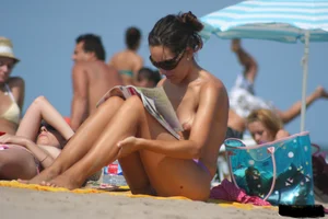 2 topless girls at the beach in thongs