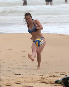 Hottie bikini babe on the beach kicking around a volleyball