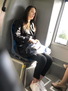 Extremely cute girl in leggings sitting in a public bus