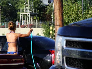 Group of cute girls at a car wash in bikinis and shorts