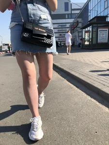 A very cute street candid girl wearing a denim fringed skirt passing by, great legs