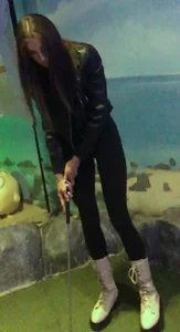 Skinny girl in a leather jacket and leggings playing mini-golf creepshots