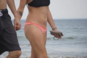 Peach bikini tattood babe on the beach with a nice ass and some camel toe