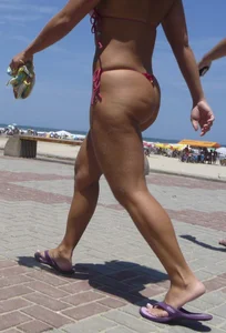 Big booty babe walking by the beach in thong