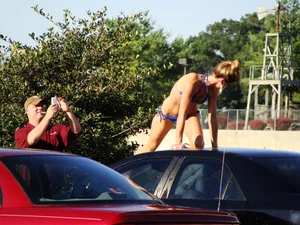 Group of cute girls at a car wash in bikinis and shorts