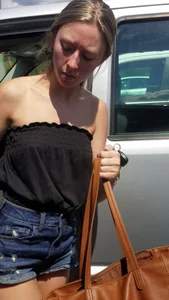 Pretty babe with small boobs in black top getting out of her car
