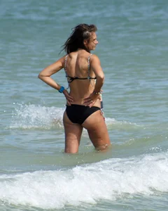 Older mature beach lady in a black bikini