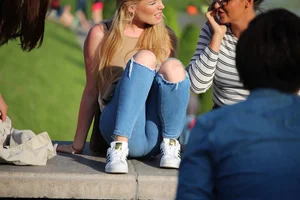 Girl in Blue Torn Jeans Sitting in the Park Creepshots