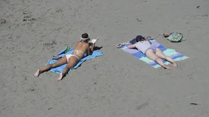 Sexy beach girl laying out in white bikini with nice body