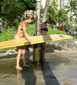 Skinny blonde surfer on the beach in little bikini