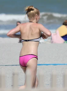 Skinny blonde girl on the beach in her pink and white bikini