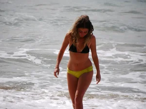 Sexy girl in yellow and black bikini on the beach