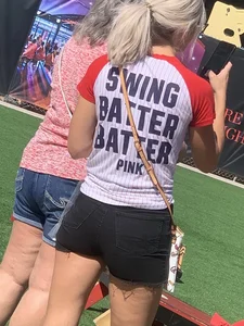 Bunch of girls in various outfits at a Cardinals baseball game