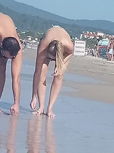 Smooth bodied and sexy blonde at the beach in a thong bikini