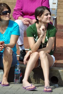 Cute brunette sitting in white shorts and showing a little cleavage