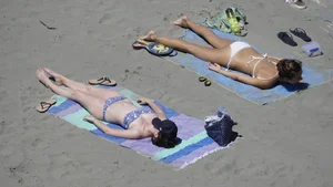 Sexy beach girl laying out in white bikini with nice body
