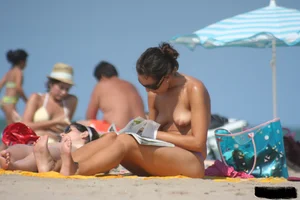 2 topless girls at the beach in thongs
