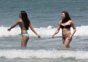 Brunette and redhead on the beach in bikinis looking sexy