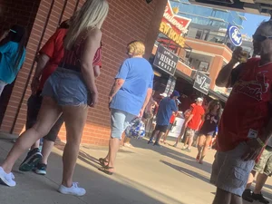 Bunch of girls in various outfits at a Cardinals baseball game
