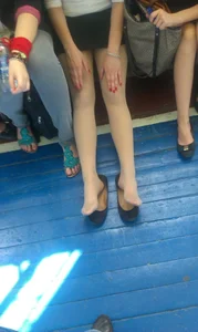 College Candid Teen Sitting on a Bench in the Gymnasium With Her Hands Resting On Her Thighs - Legs in Pantyhose And Flats Taken Off