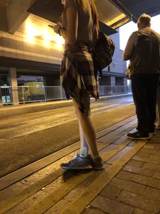 Cute Teen in Shorts on the Tram Stop
