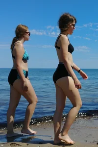 2 sexy friends in bikinis walking on the beach