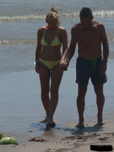 Sexy blonde on the beach in a yellow thong bikini