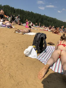 Girl in Red Swimsuit Lying on Her Stomach With Spread Legs on a Beach Creepshots