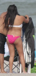 Brunette bikini girl on the beach and surfing in her bikini