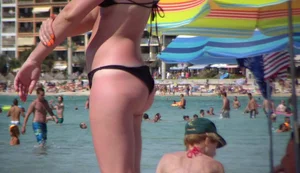 Amazing ass in semi-thong bikini on the beach with tanlines