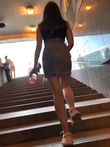 Hot chick wearing a fringed skirt walking up the stairs