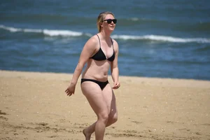 Chunky blonde in a black bikini on the beach