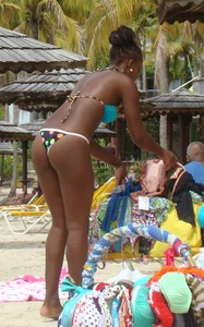 Sexy black babe in various bikinis on the beach while on vacation