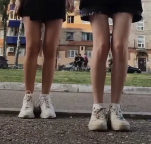 Slim Legs of Young Girls in Skirts And Sneakers Street Creepshot