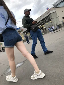 Candid Girl in Blue Denim Shorts and Sneakers Walking Down the Street - Hot Legs Crepshots Collection