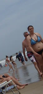 Big boobed girl on the beach in blue and black bikini