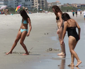 Brunette and redhead on the beach in bikinis looking sexy