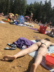 Topless Skinny Girl With Very Pale Skin Lying on a Beach on Her Tummy With Slightly Spread Legs Creepshots Gallery